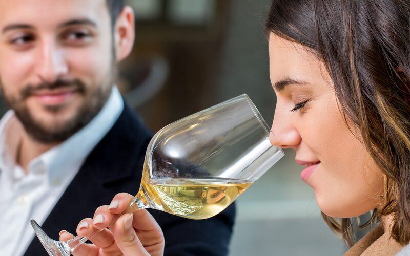 Frau prüft das Aroma eines Weißweins im Glas