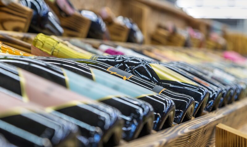Weinflaschen liegen sortiert in einem Weinregal