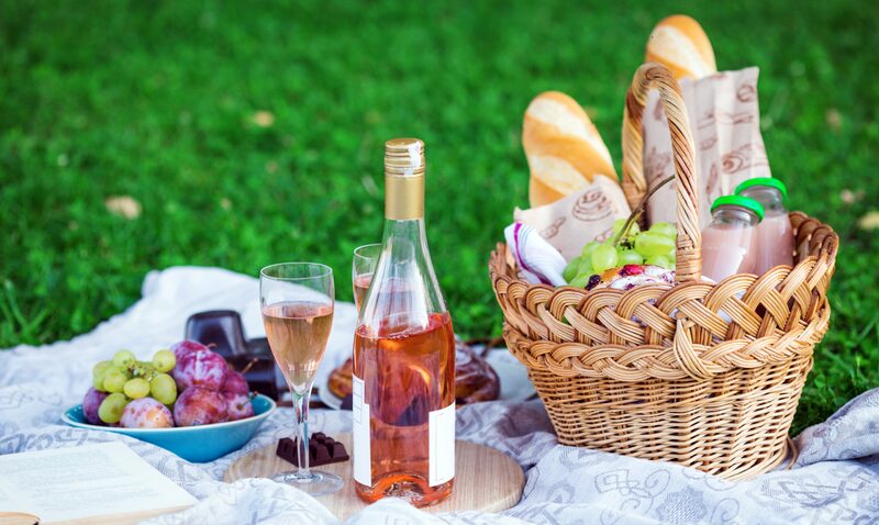 Picknick mit Roséwein, Baguette und Picknickkorb